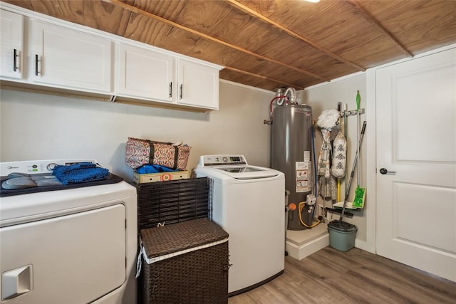 clothes washing area featuring cabinets, wood ceiling, water heater, washer and dryer, and hardwood / wood-style floors