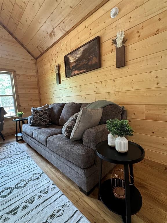 living room featuring hardwood / wood-style floors, wooden ceiling, wooden walls, and vaulted ceiling