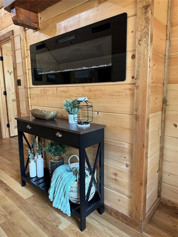 room details featuring wooden walls and hardwood / wood-style floors