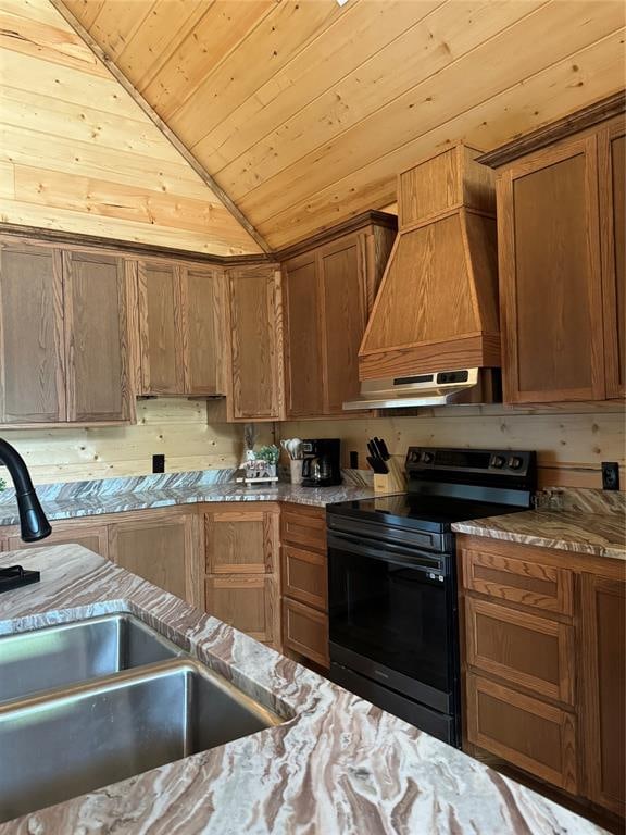 kitchen with sink, light stone counters, black electric range, premium range hood, and vaulted ceiling