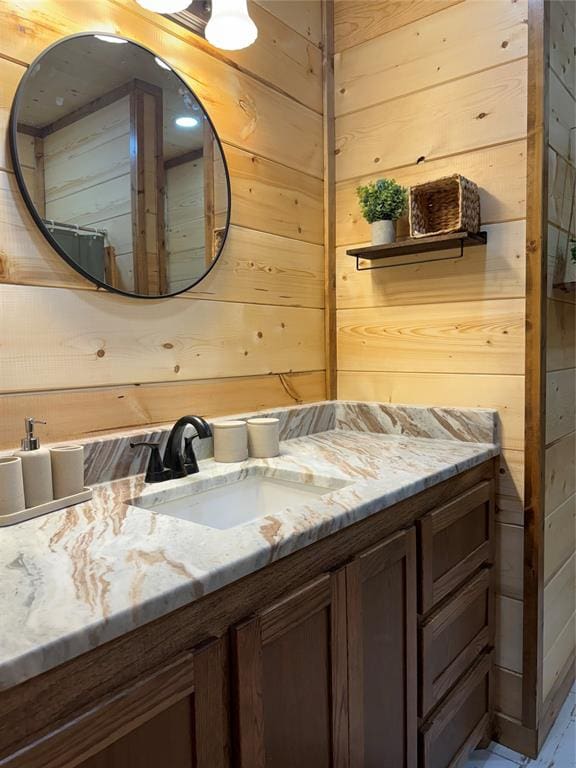 bathroom featuring a shower with shower curtain, vanity, and wooden walls