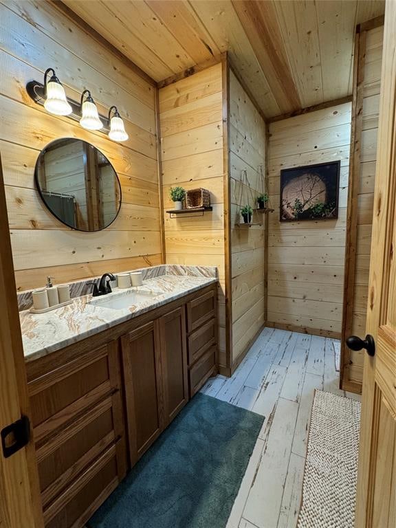 bathroom with hardwood / wood-style floors, vanity, wooden ceiling, and wood walls