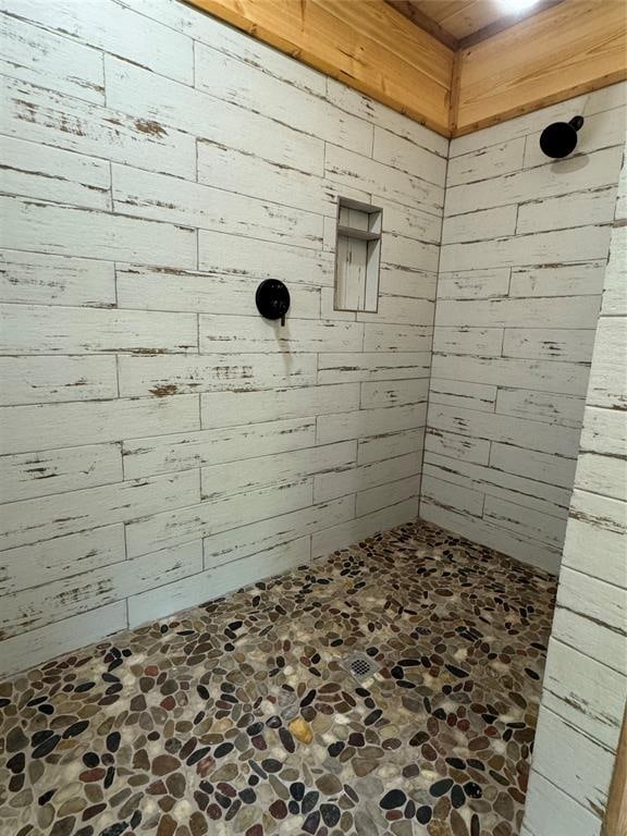 bathroom featuring wood walls and a shower