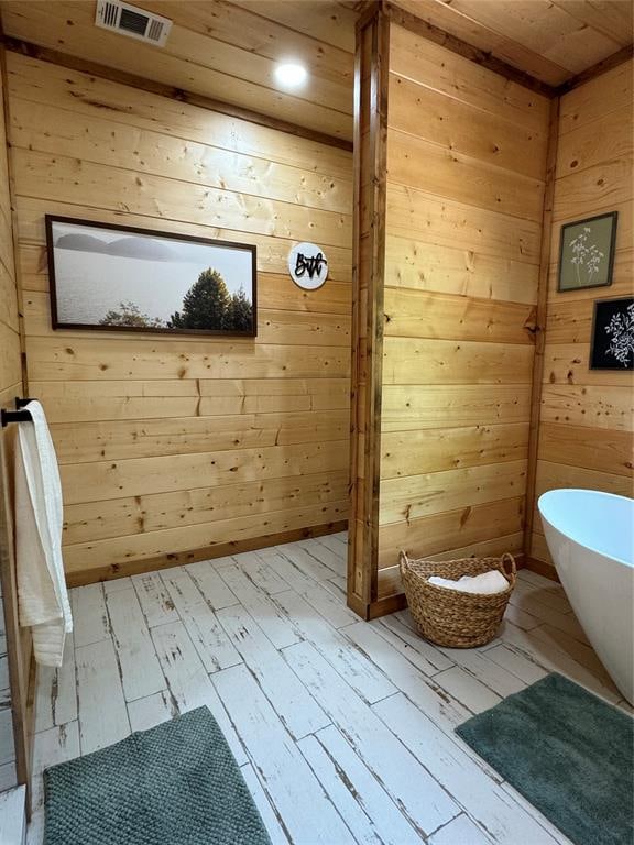 bathroom featuring hardwood / wood-style floors and wooden walls