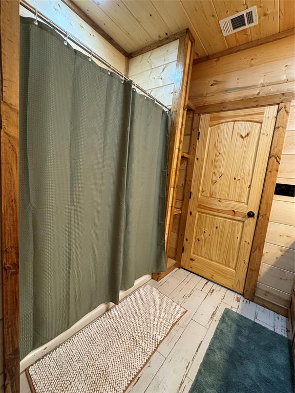 bathroom with hardwood / wood-style floors and wooden ceiling