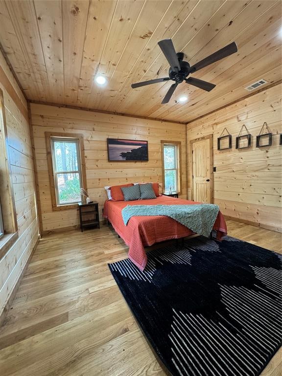 bedroom featuring wooden walls, ceiling fan, wood ceiling, and light wood-type flooring