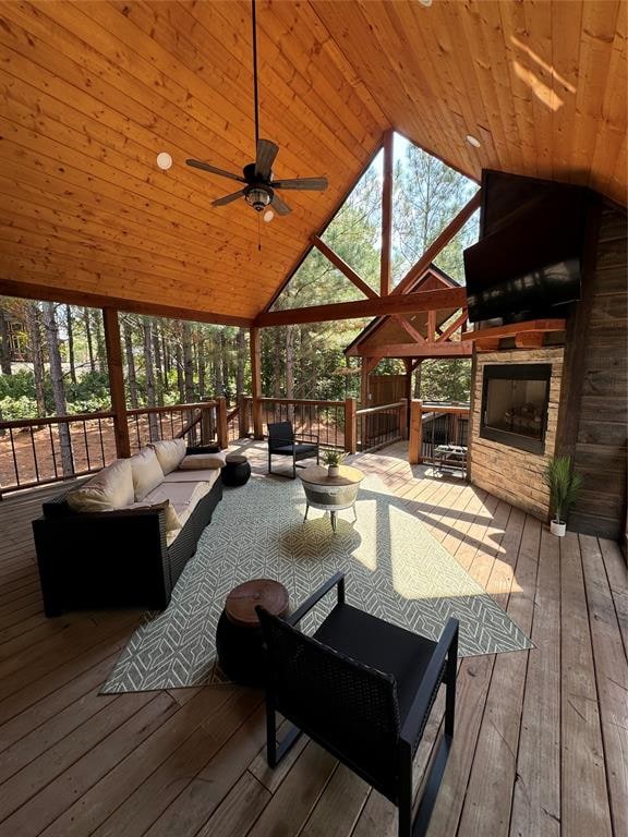 wooden deck with an outdoor living space with a fireplace, ceiling fan, and a gazebo