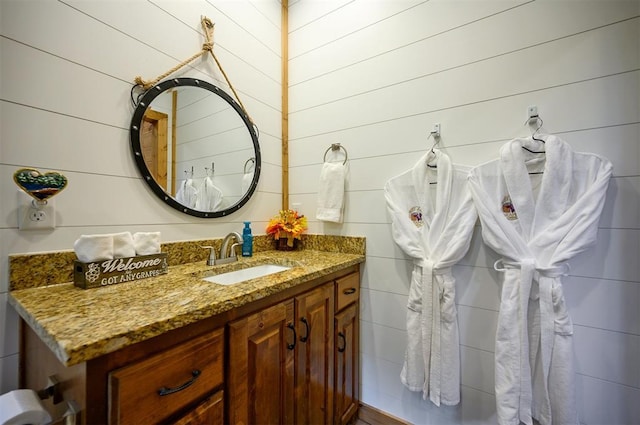 bathroom featuring vanity and wooden walls