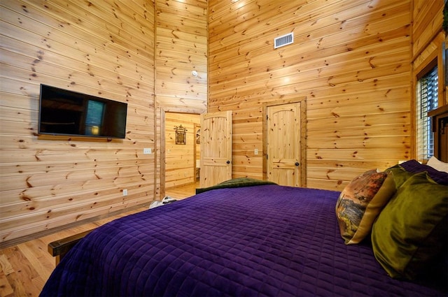 bedroom with wood walls and hardwood / wood-style floors