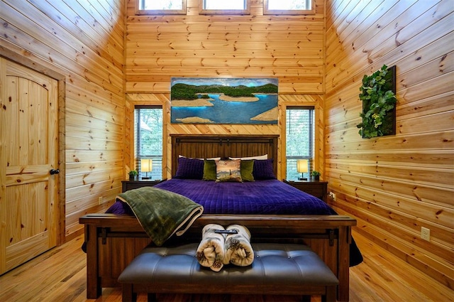 bedroom featuring light wood-type flooring and wood walls