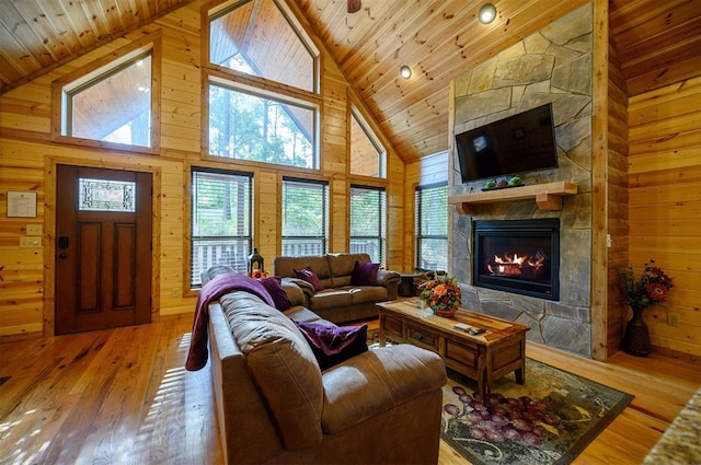 living room featuring hardwood / wood-style flooring, high vaulted ceiling, wood ceiling, and wood walls