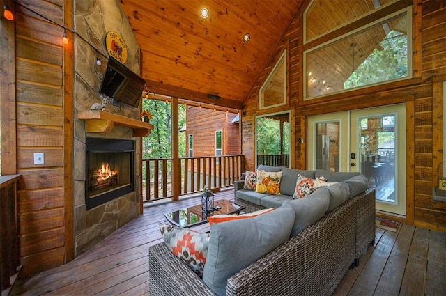 sunroom / solarium with plenty of natural light, an outdoor stone fireplace, wooden ceiling, and vaulted ceiling