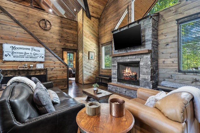 living room with wood walls, a stone fireplace, wood ceiling, and high vaulted ceiling