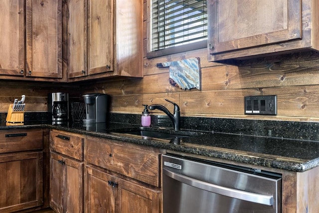 kitchen featuring backsplash, dark stone countertops, sink, and stainless steel dishwasher