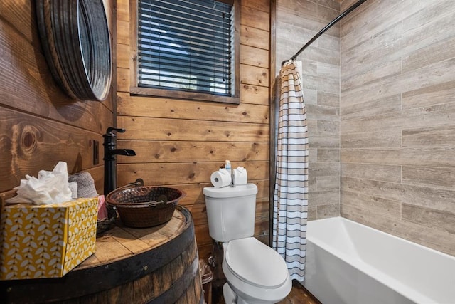 bathroom featuring wooden walls, shower / bath combination with curtain, and toilet