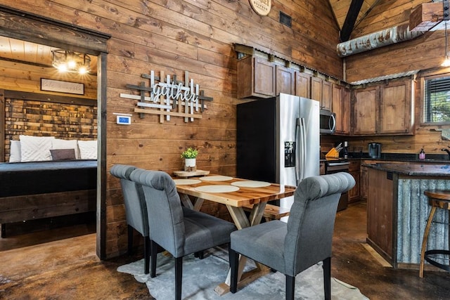 dining area featuring wooden walls, lofted ceiling, and sink