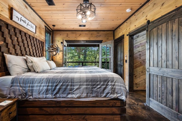 bedroom with a barn door, wooden ceiling, and wood walls