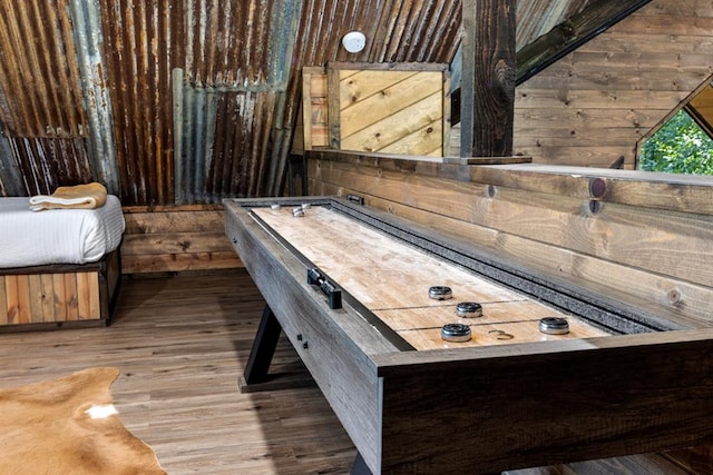 game room featuring wood-type flooring and wood walls