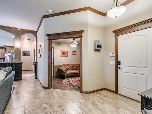 foyer entrance with crown molding and ceiling fan