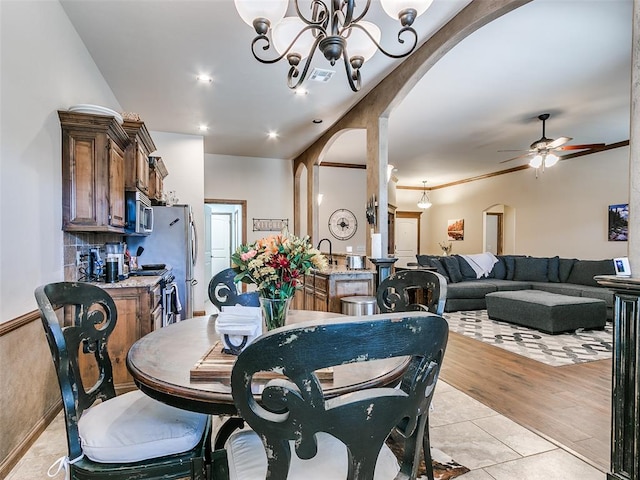 dining room with light wood-type flooring and ceiling fan with notable chandelier