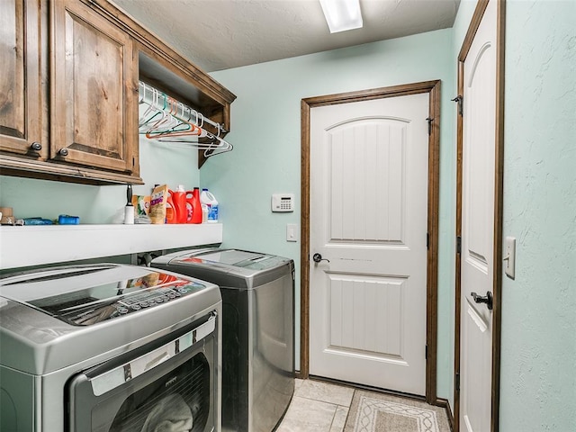 washroom featuring washing machine and clothes dryer and cabinets