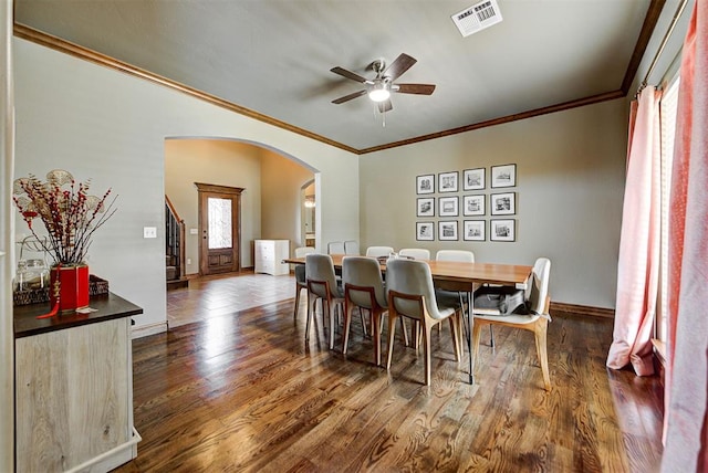 dining room with a healthy amount of sunlight, dark hardwood / wood-style flooring, and crown molding