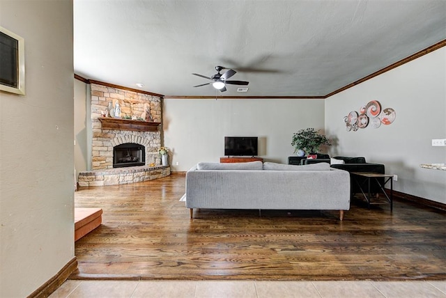 living room with ceiling fan, a fireplace, crown molding, and hardwood / wood-style flooring