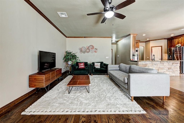 living room with dark hardwood / wood-style floors, ceiling fan, sink, and crown molding