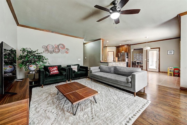 living room featuring hardwood / wood-style flooring, ceiling fan, and crown molding