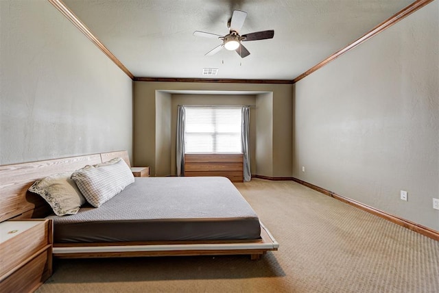 carpeted bedroom featuring ceiling fan and crown molding