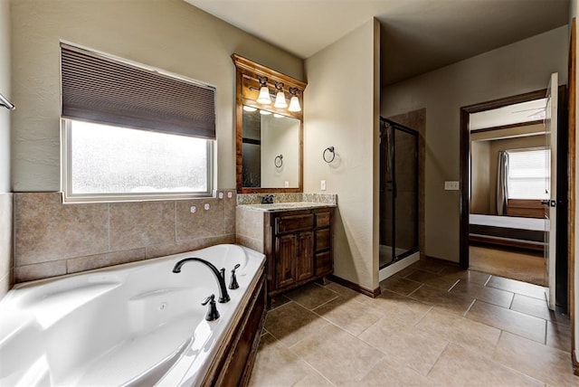 bathroom with tile patterned flooring, vanity, and shower with separate bathtub