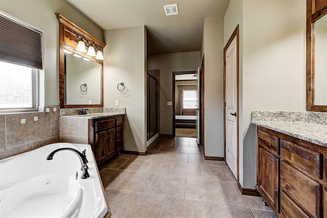 bathroom with a wealth of natural light, tile patterned flooring, vanity, and plus walk in shower