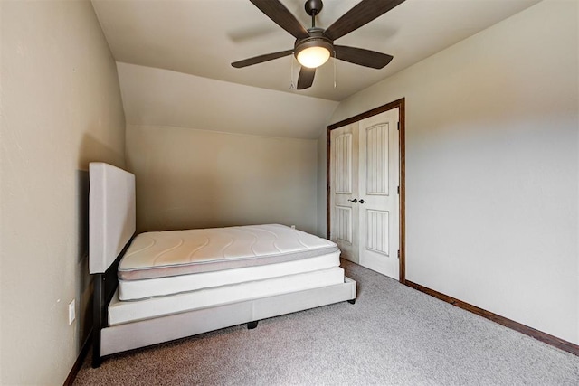 unfurnished bedroom featuring carpet, ceiling fan, and vaulted ceiling