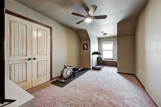 workout area with a textured ceiling, carpet floors, vaulted ceiling, and ceiling fan