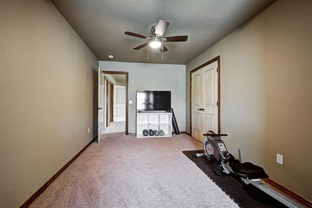 exercise area featuring light colored carpet and ceiling fan