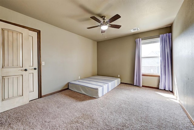 unfurnished bedroom featuring ceiling fan and carpet