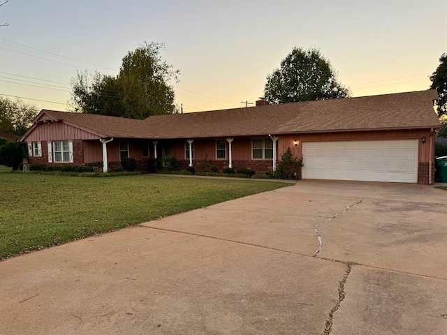 ranch-style home with a garage and a yard