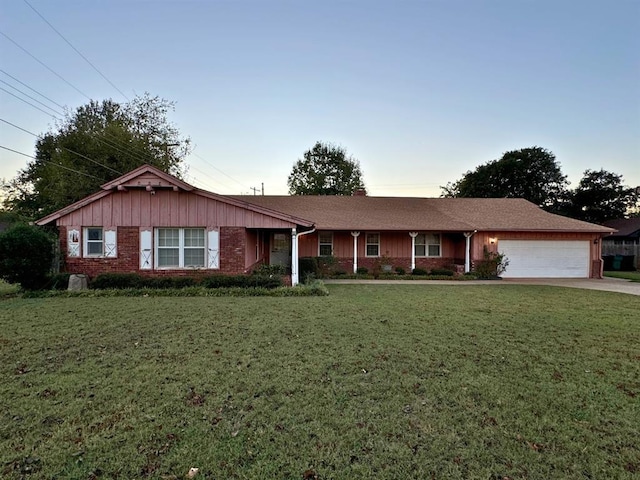 ranch-style home with a garage and a yard