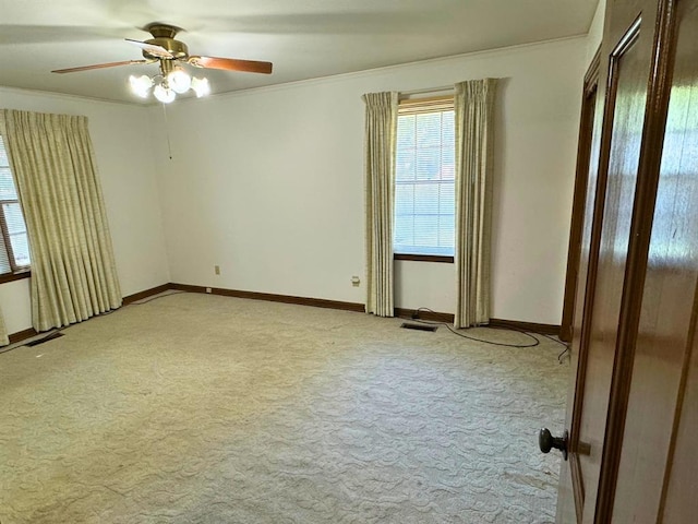 spare room with crown molding, ceiling fan, and light colored carpet