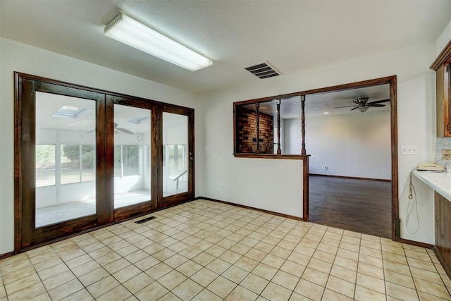 interior space with ceiling fan, french doors, a textured ceiling, and light hardwood / wood-style flooring