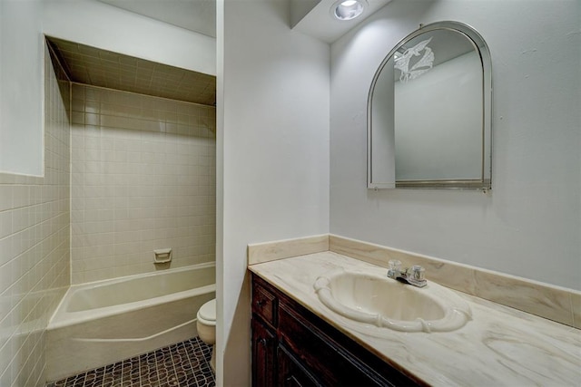 full bathroom featuring tile patterned floors, vanity, tiled shower / bath combo, and toilet