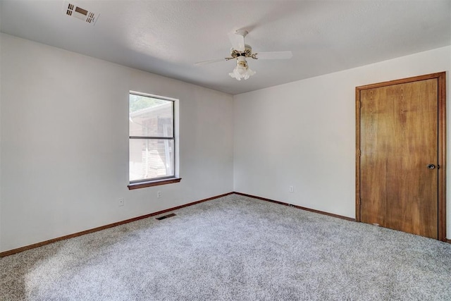 carpeted empty room with ceiling fan and a textured ceiling