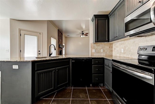 kitchen with kitchen peninsula, light stone countertops, sink, and appliances with stainless steel finishes