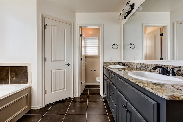 bathroom featuring tile patterned floors, vanity, toilet, and a tub