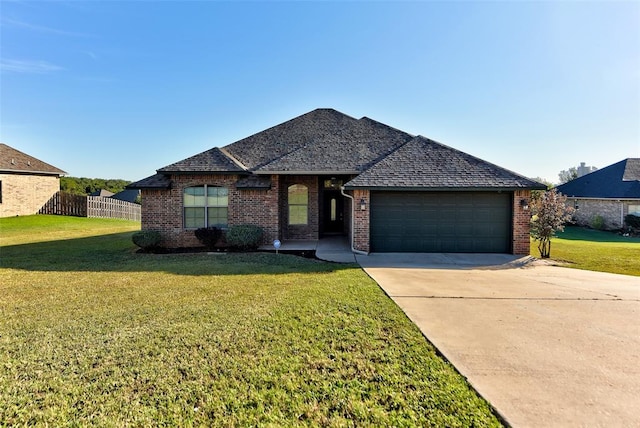 view of front of home featuring brick siding, an attached garage, fence, a front yard, and driveway