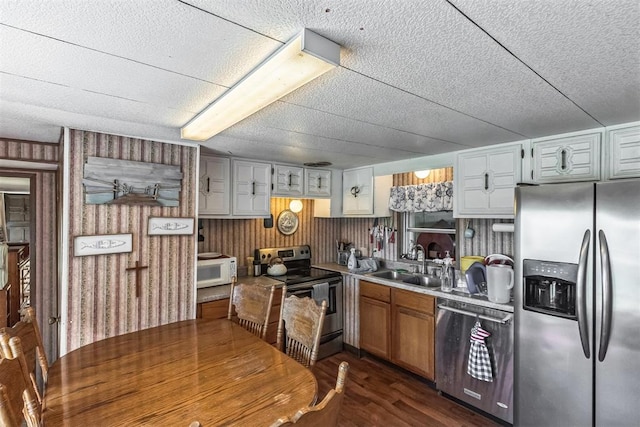 kitchen featuring white cabinetry, sink, appliances with stainless steel finishes, and dark wood-type flooring