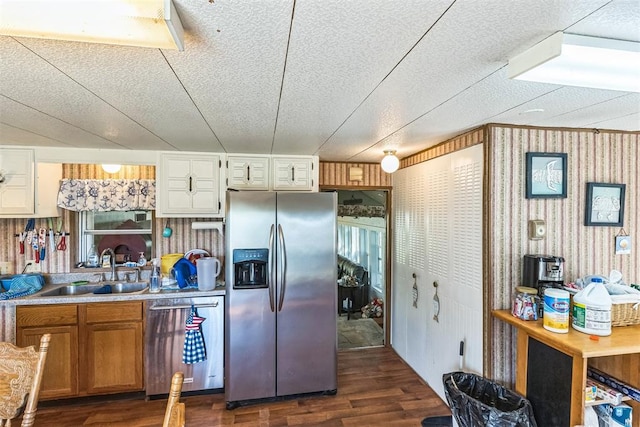 kitchen with wood walls, sink, stainless steel appliances, and dark hardwood / wood-style floors