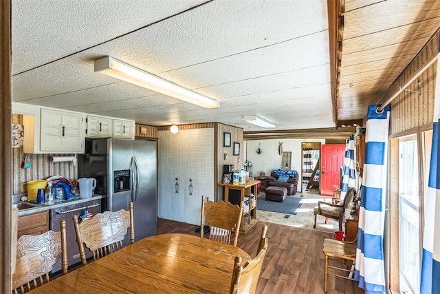 dining space with wooden walls and wood-type flooring