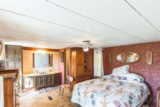 bedroom with ceiling fan, sink, and a textured ceiling