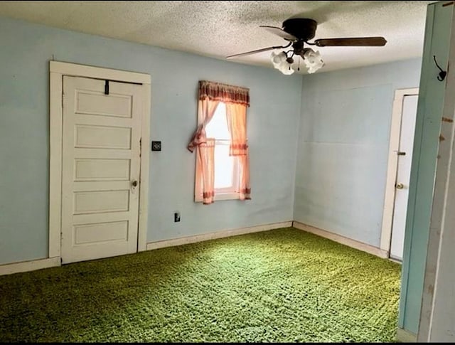 carpeted spare room with a textured ceiling and ceiling fan